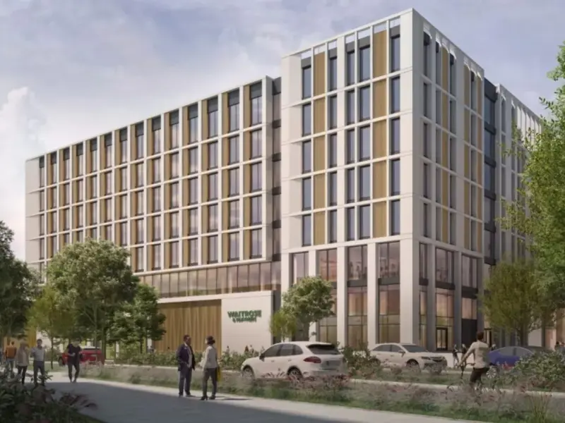 CGI of One Brabazon Gateway - a modern multi-storey building with large windows, surrounded by trees and pedestrians on a sidewalk. 