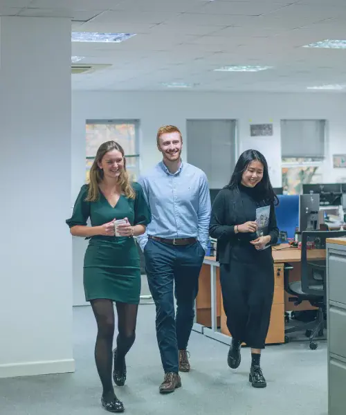 Three YTL Developments employees standing and smiling in an office