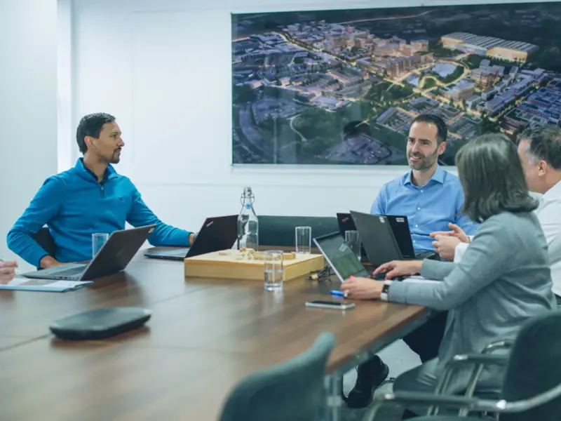 Four YTL Developments employees talking in an office meeting room